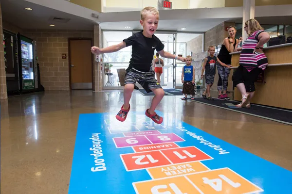 kid jumping on hop scotch board at Sampson Family Y YMCA Pittsburgh